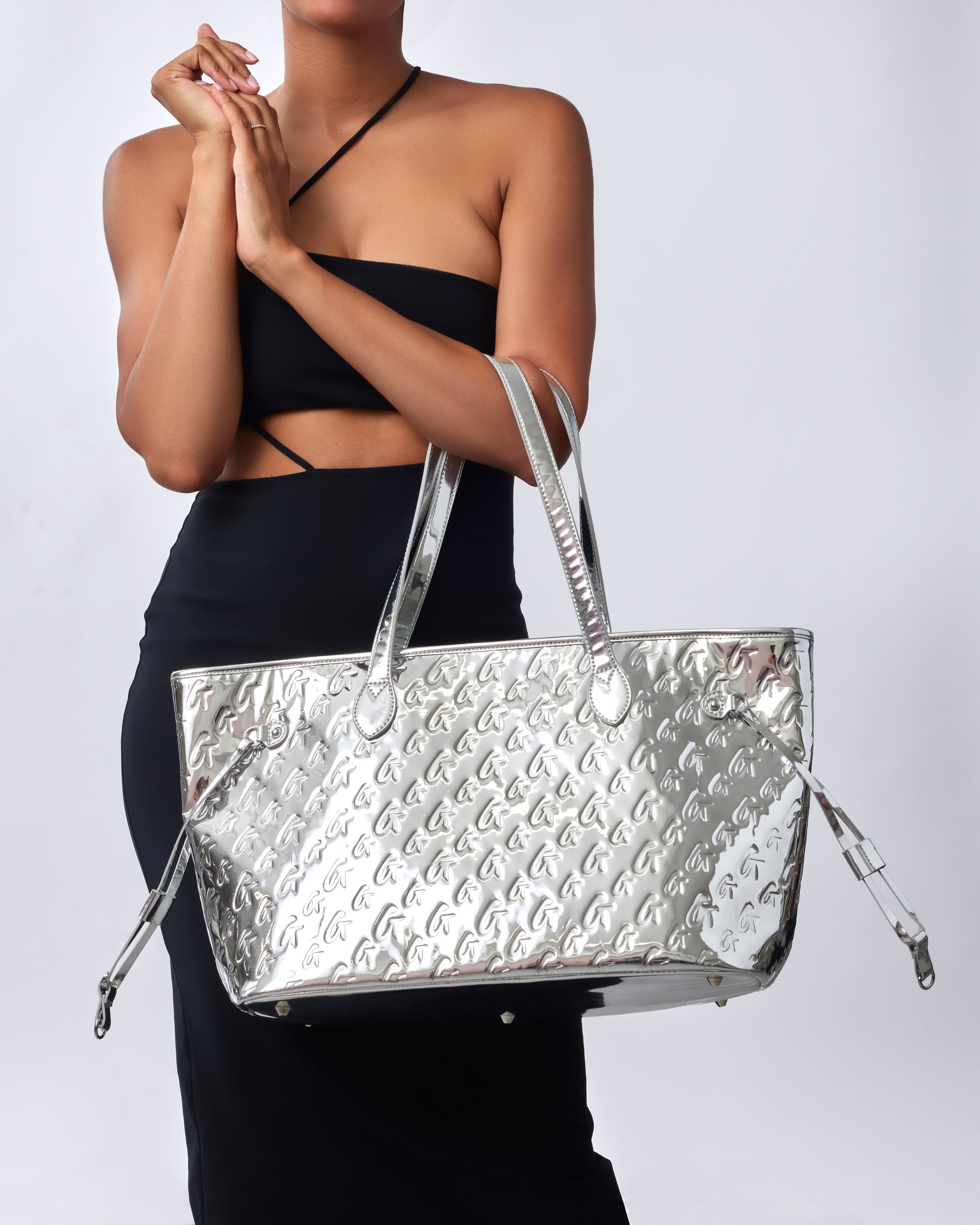 Metallic silver tote bag featuring a monogram design, perfect for stylish women seeking affordable luxury.