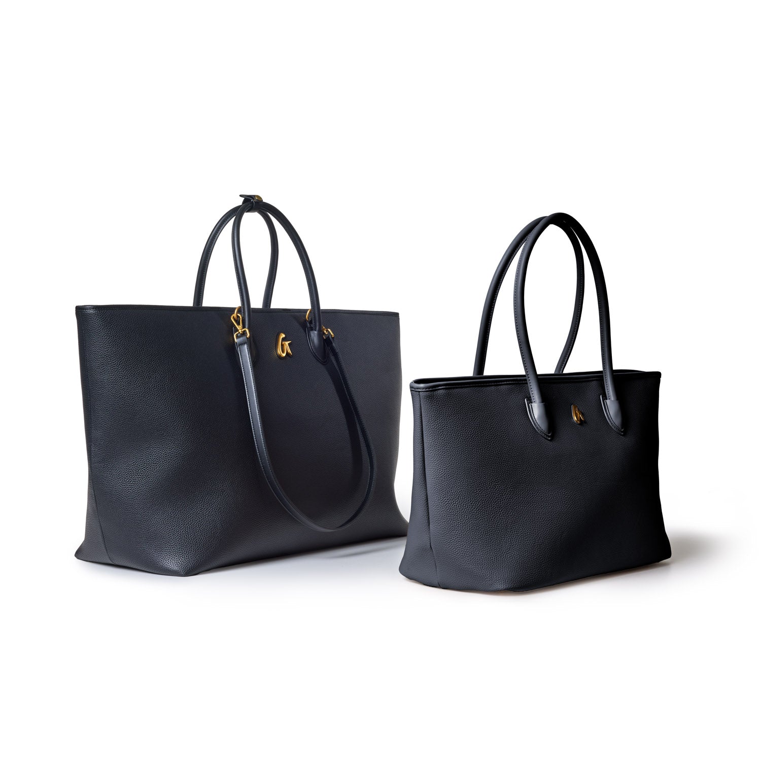 Two black leather tote bags with textured finish, gold accents, and double handles, suitable for everyday use.