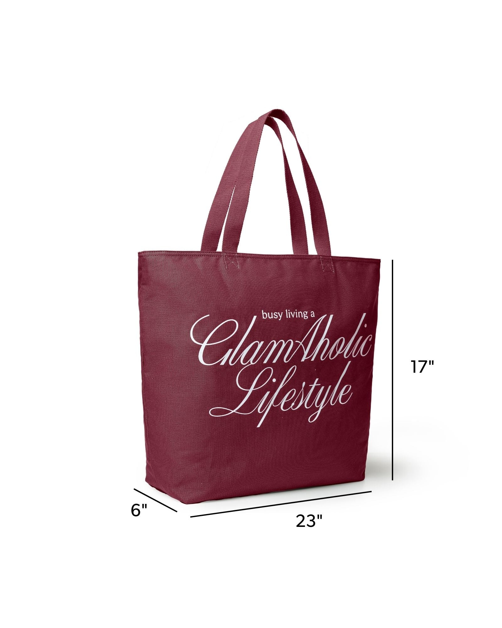 Burgundy canvas tote bag with "busy living a GlamAholic Lifestyle" printed in white, measuring 23x17x6 inches.