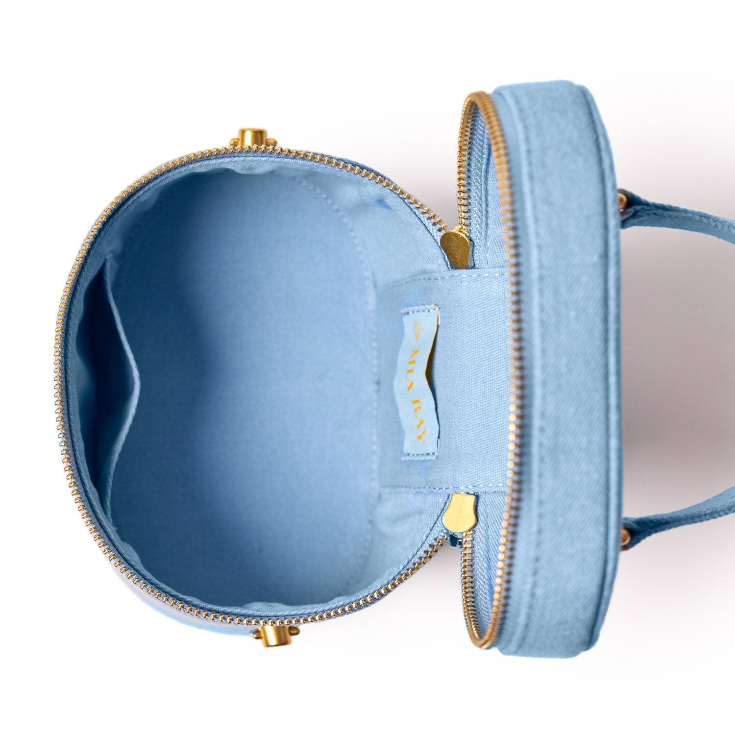 Open blue denim vanity bag with gold zipper and interior compartments, designed for cosmetics and accessories storage.