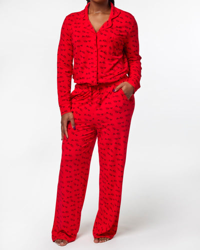 Red women's pajama set featuring a button-up top and matching pants with a stylish print, perfect for cozy nights.