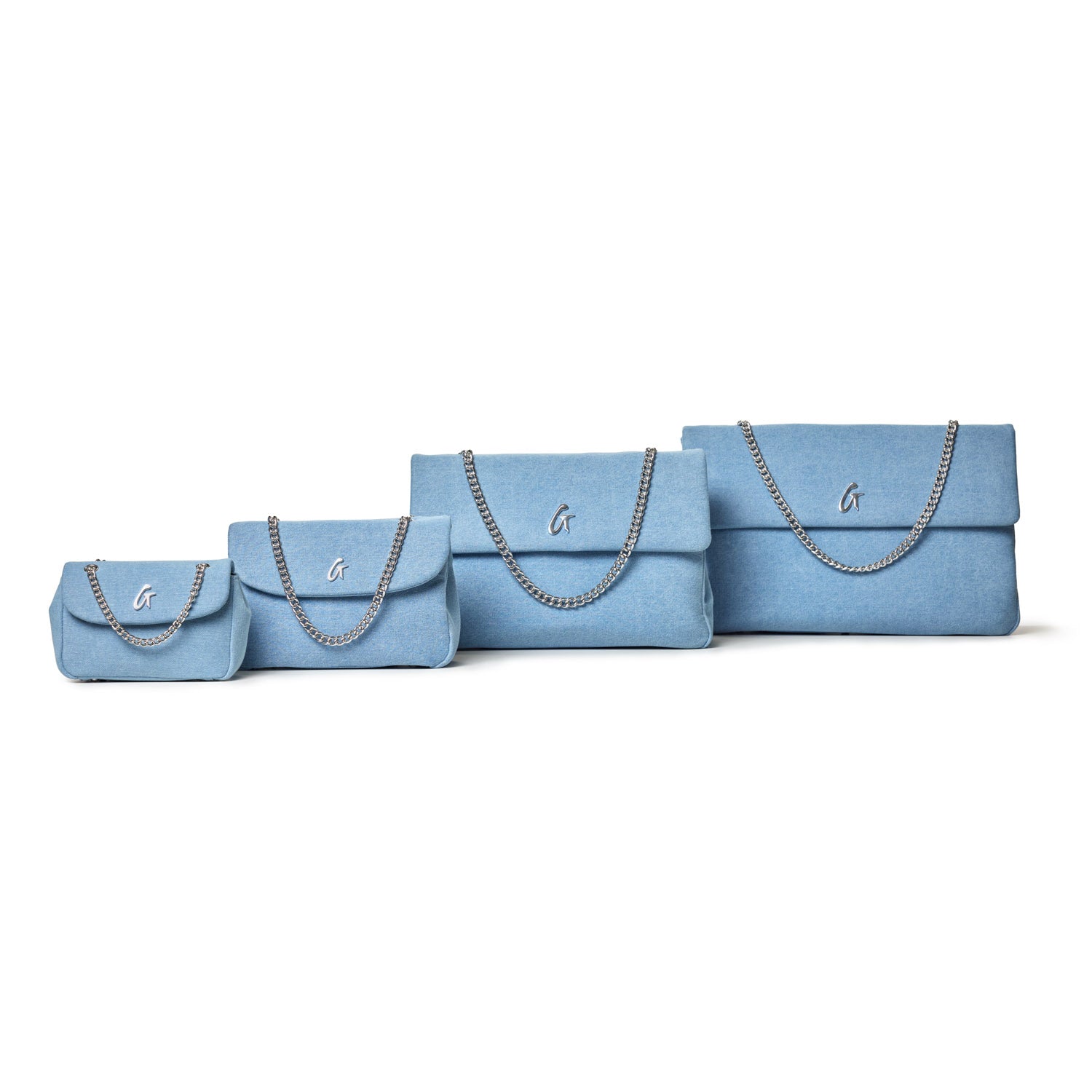 Four blue denim silver flap bags in varying sizes, each with a chain strap and a silver "G" logo on the front.
