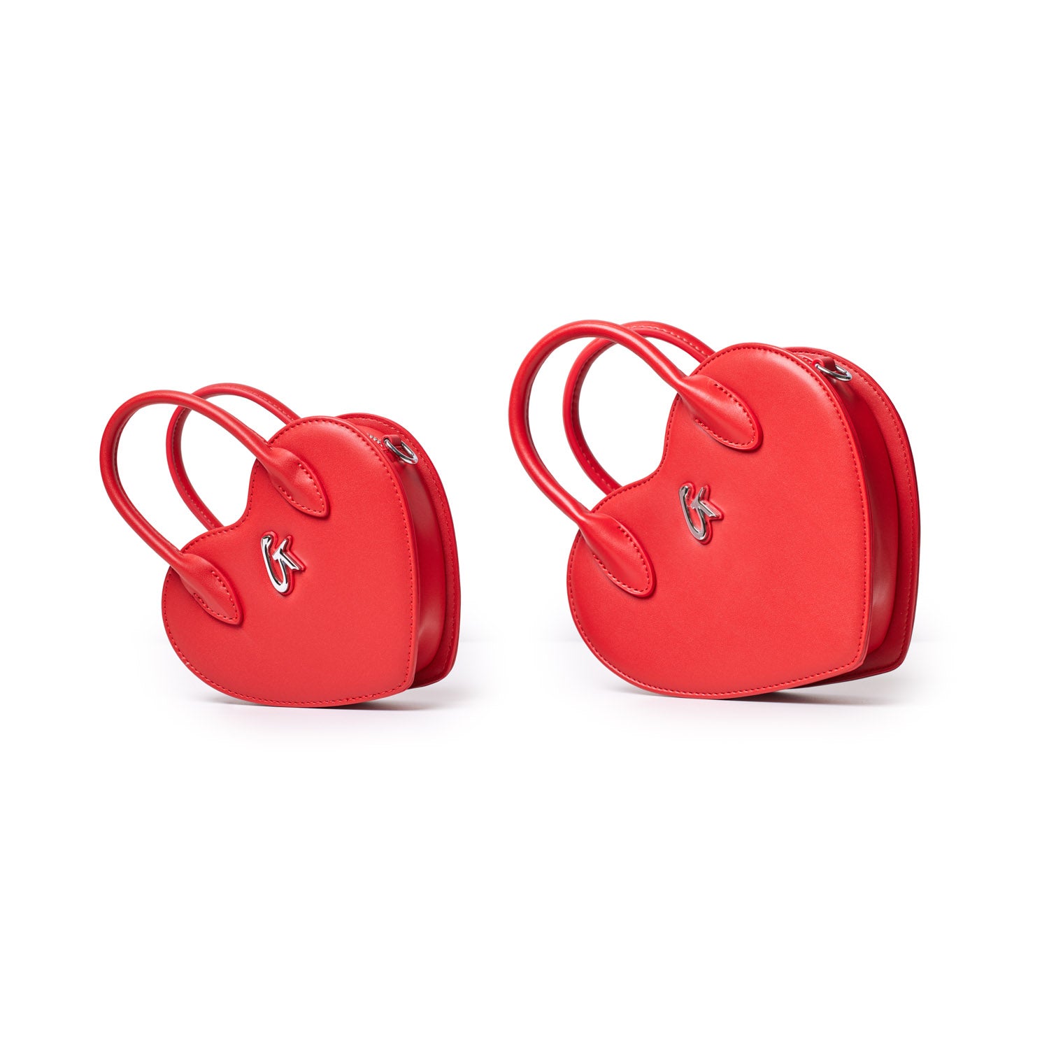 Two red mini heart-shaped bags with top handles and silver logo accents, perfect for small accessories or essentials.