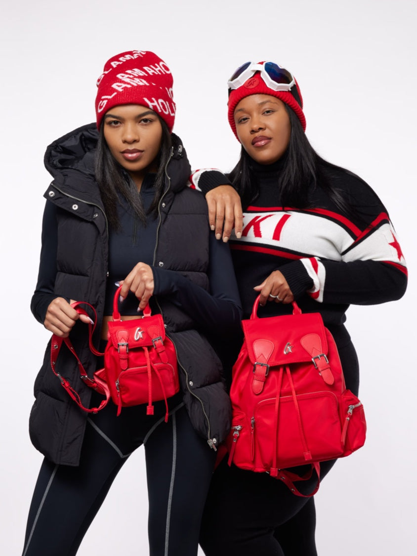 Two women showcase a red mini nylon backpack, styled with winter outfits, highlighting affordable luxury fashion.