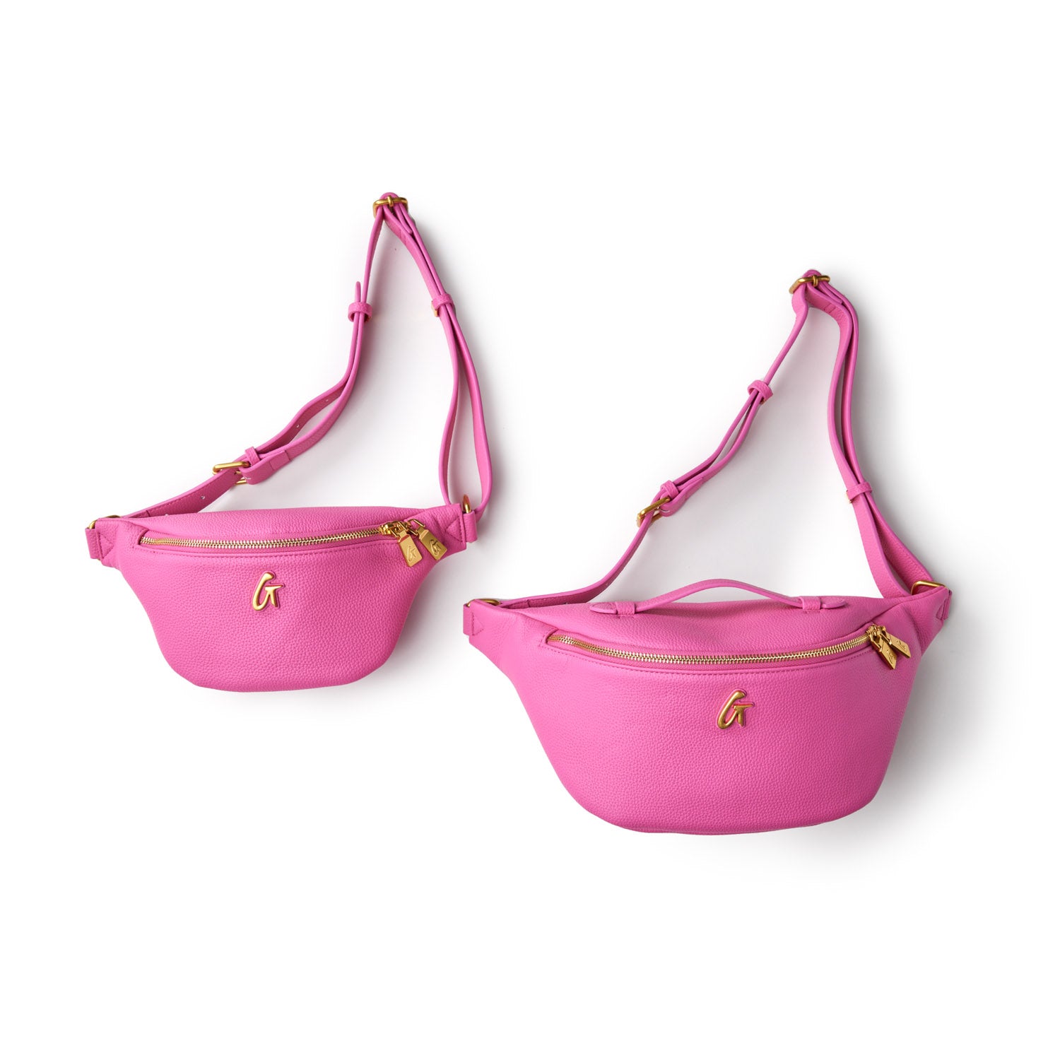 Pair of hot pink Pebble Fanny Packs with gold zippers and adjustable straps, designed for casual, hands-free style.