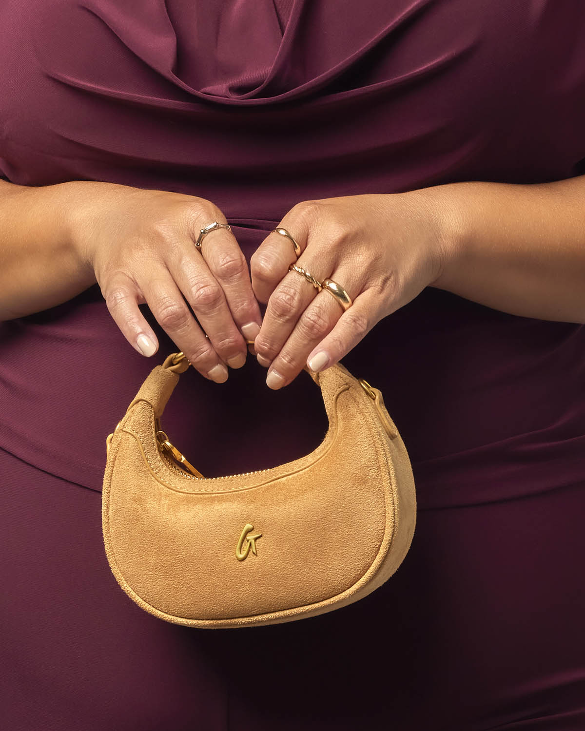 Tan nano suede hobo bag held by a person, featuring a stylish design perfect for affordable luxury.