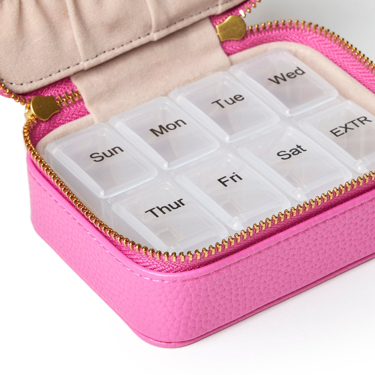 Hot pink pebble pill case with a zippered closure, featuring compartments labeled for each day of the week.