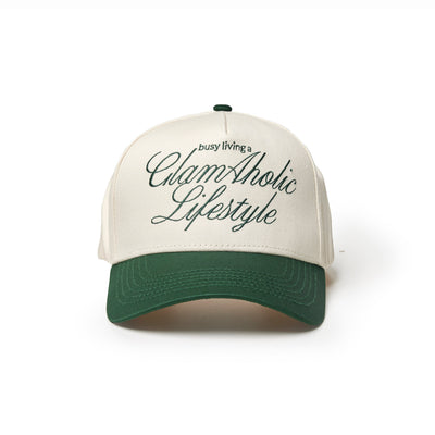 Green trucker hat featuring the phrase "busy living a GlamAholic Lifestyle" in stylish script.