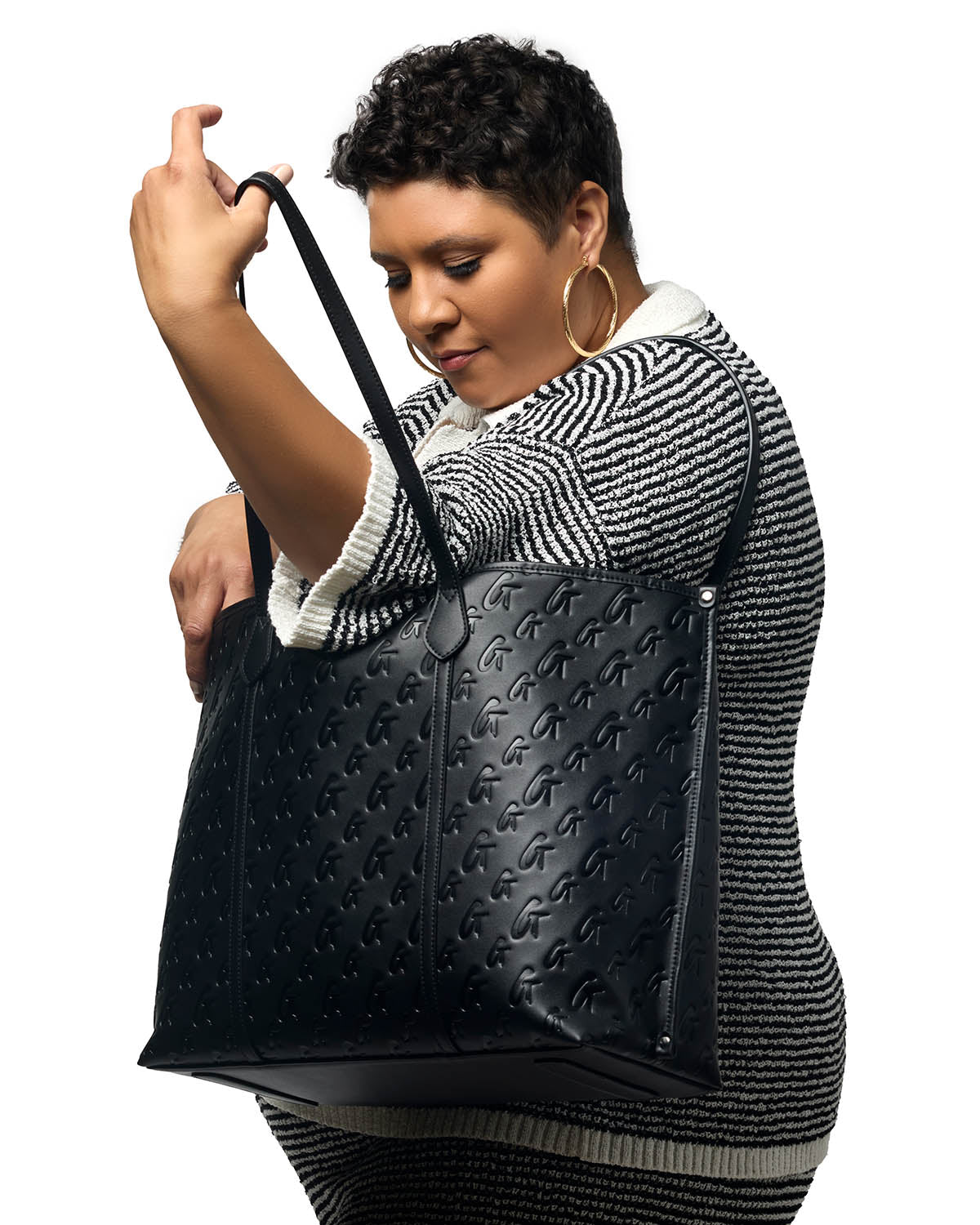 Model showcasing the XL Monogram Sleek Tote in black, featuring a stylish embossed design and spacious interior.