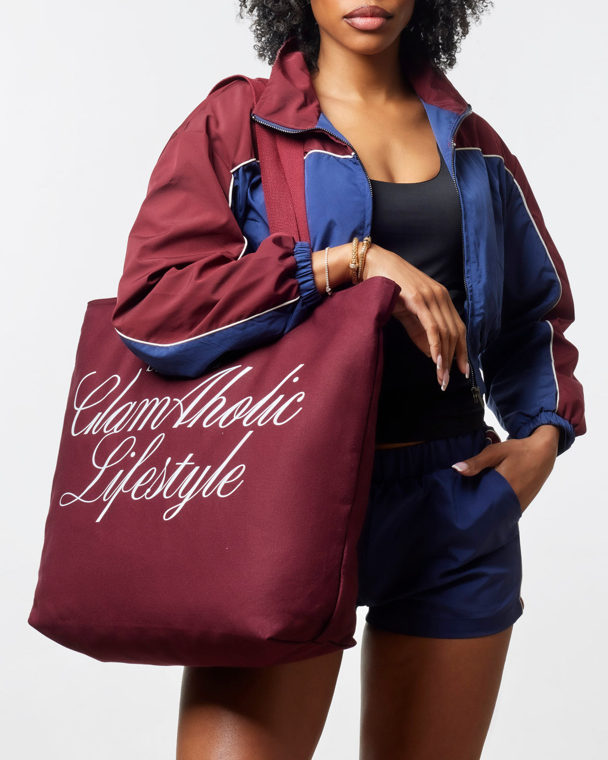 Burgundy canvas tote bag featuring Glam-Aholic Lifestyle logo, styled with a sporty outfit. Perfect for everyday use.