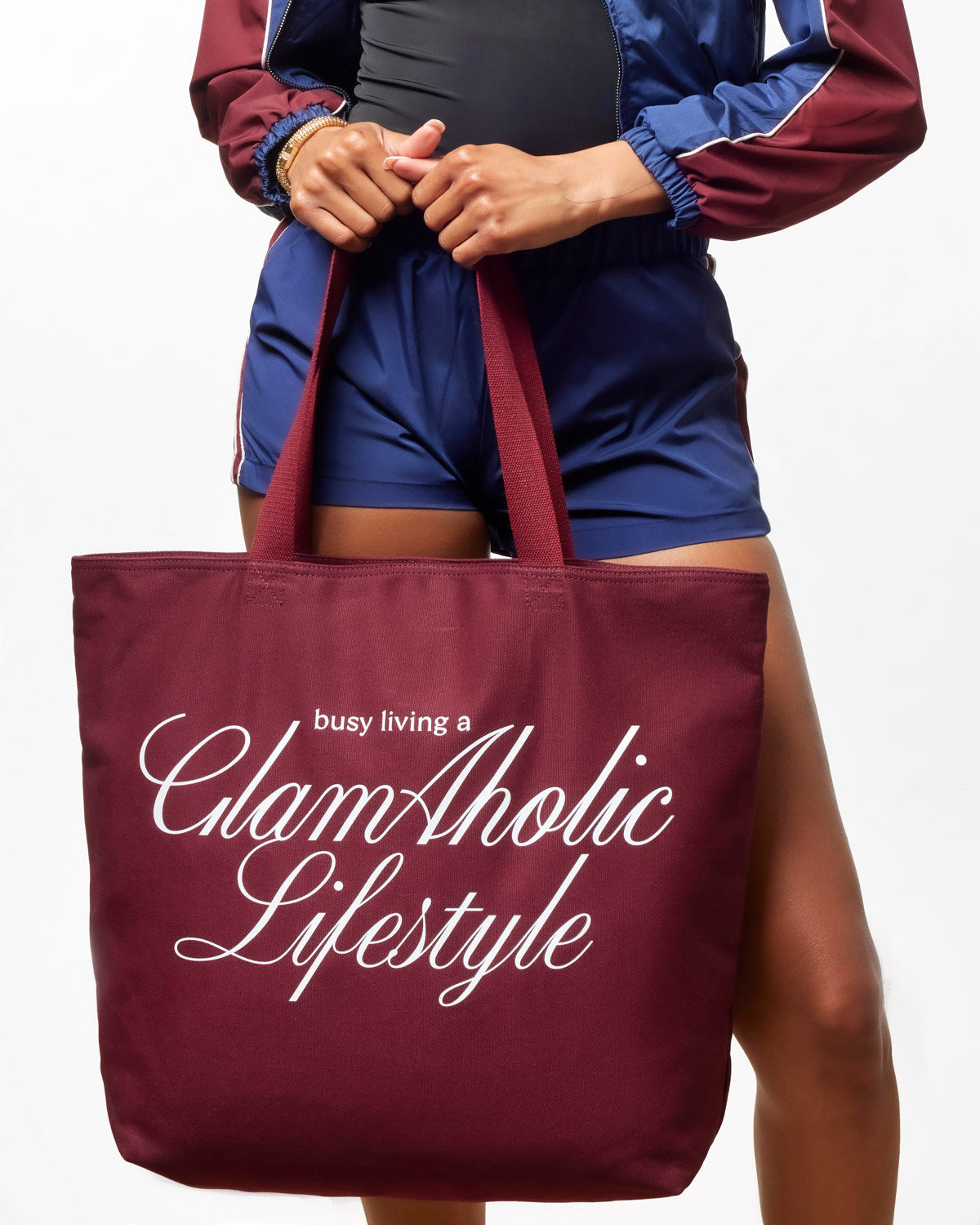 Burgundy canvas tote bag featuring "busy living a Glam-Aholic Lifestyle" text, perfect for stylish everyday use.