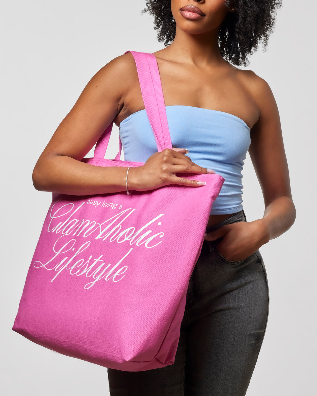 Hot pink canvas tote bag with "Busy Living a Glam-Aholic Lifestyle" printed, perfect for stylish, everyday use.