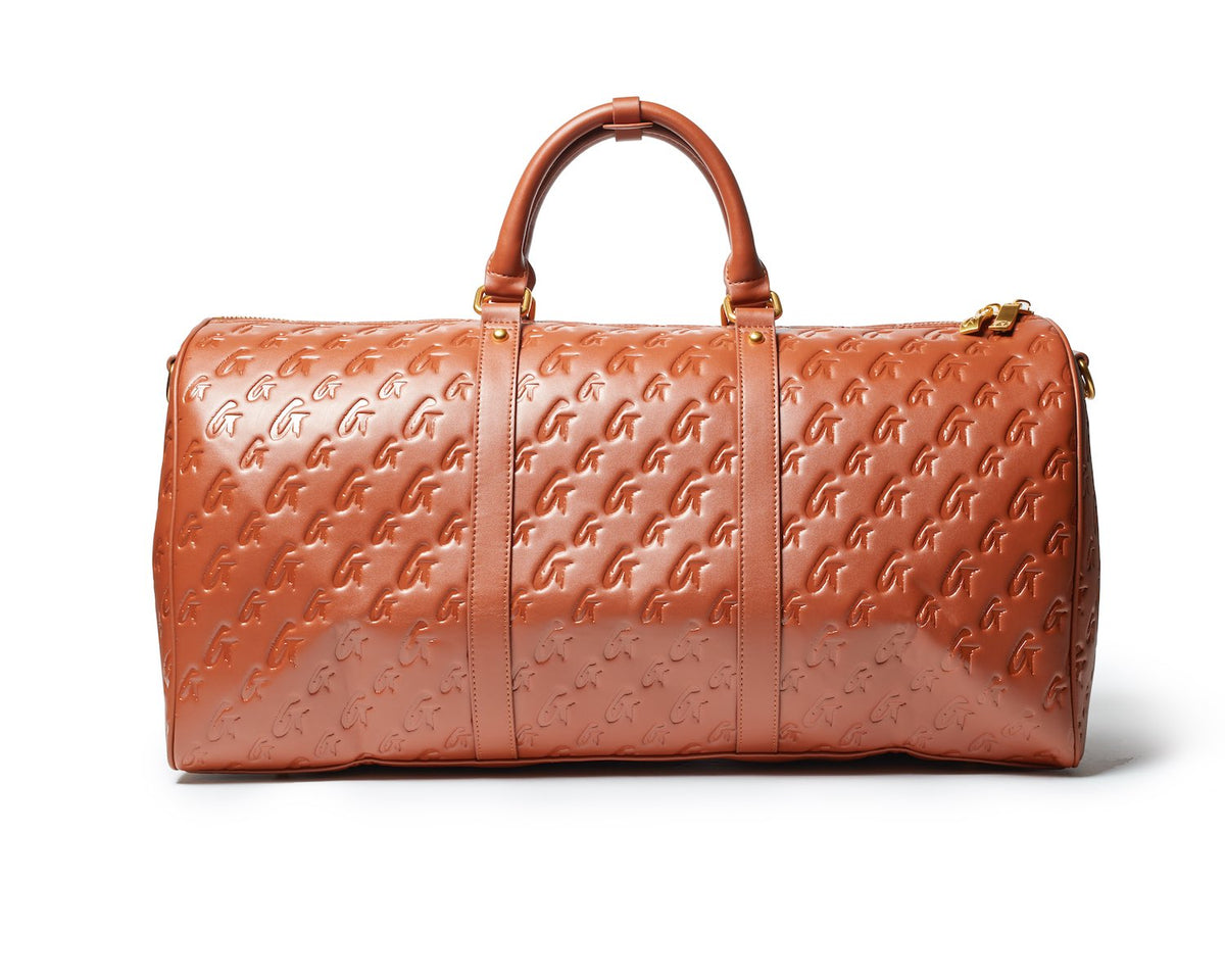 Brown monogram travel set featuring a spacious duffel bag with embossed logo and sturdy handles for stylish travel.