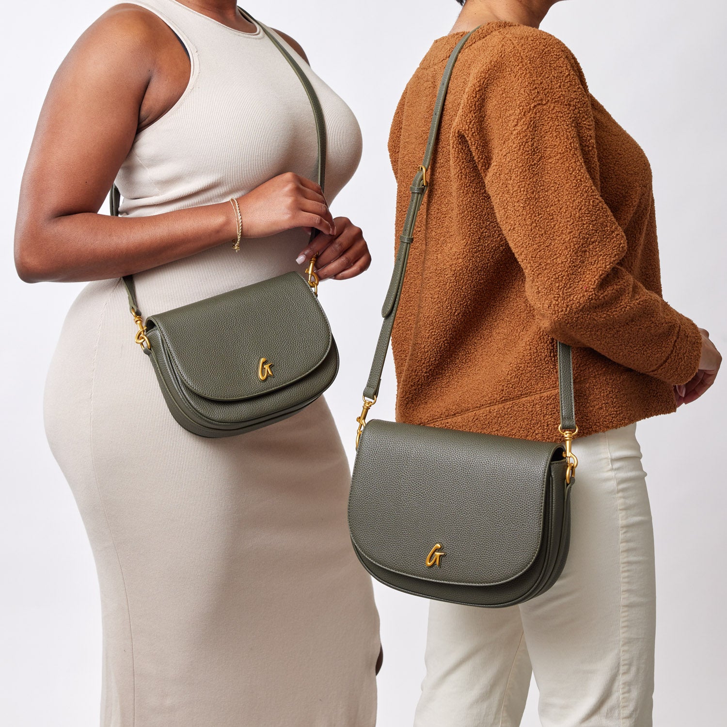 Two women showcase olive green large pebble shoulder bags with gold accents, styled with neutral outfits.