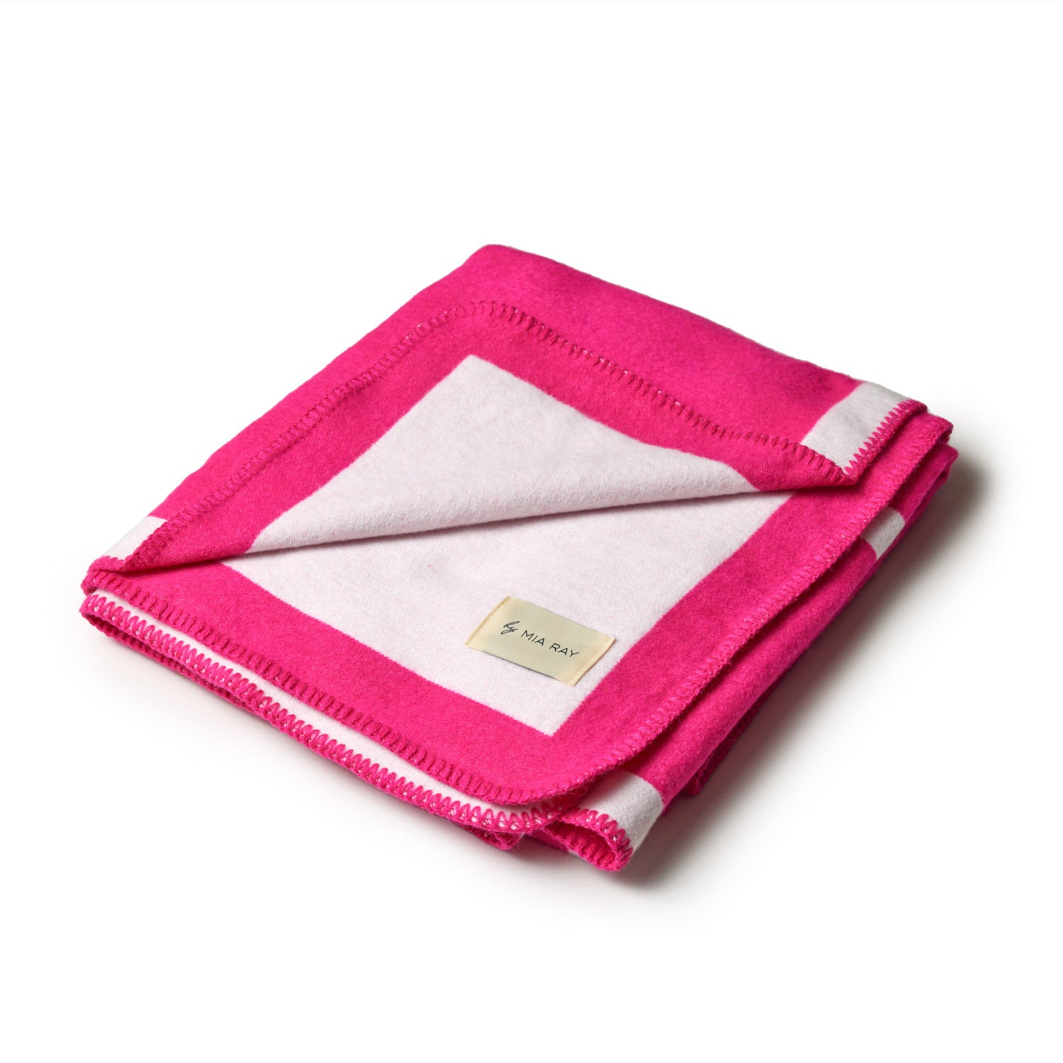 Soft hot pink and white classic throw blanket, folded with a label, perfect for cozying up on the couch.