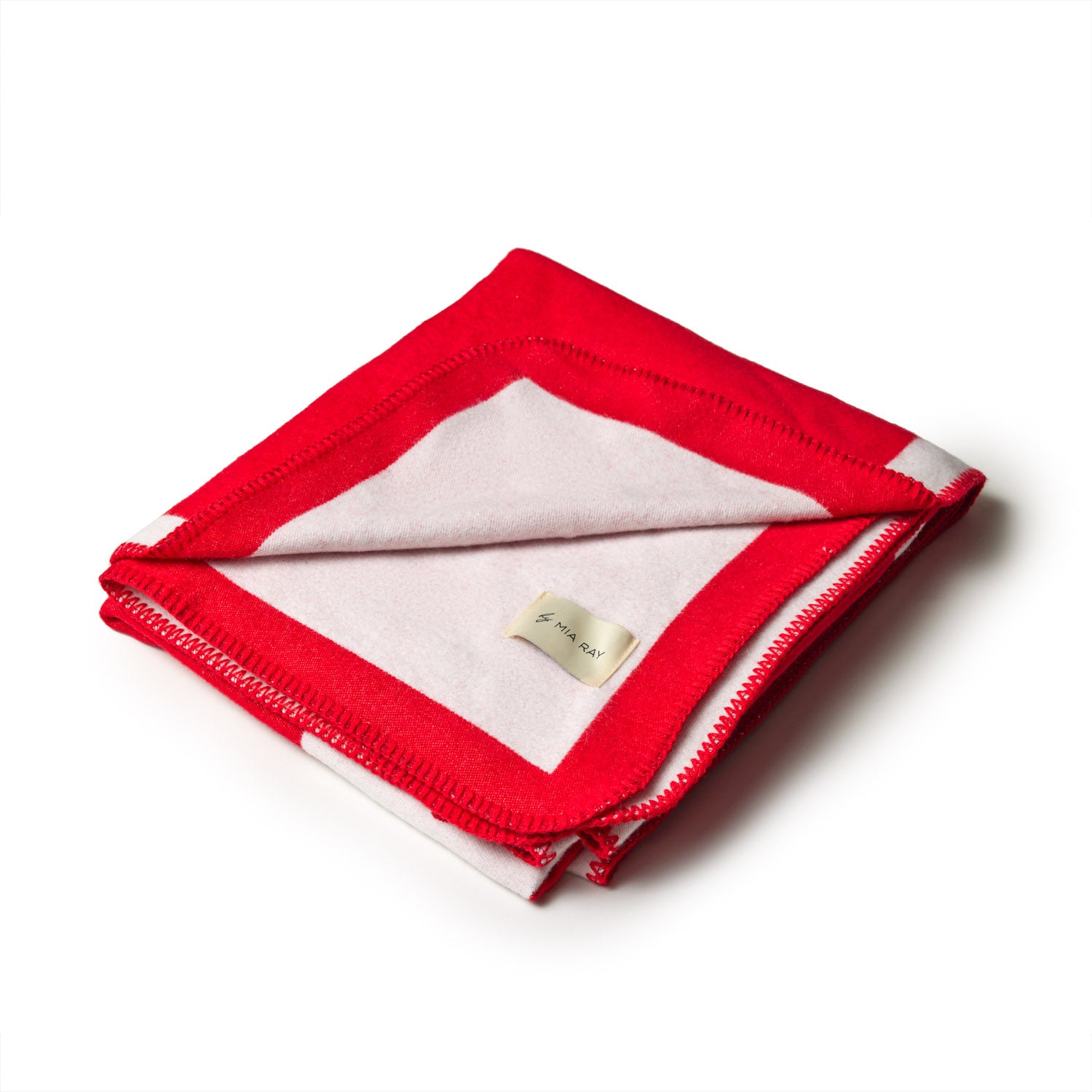 Red and white classic throw blanket, folded with visible stitching and a small fabric label, on a white background.