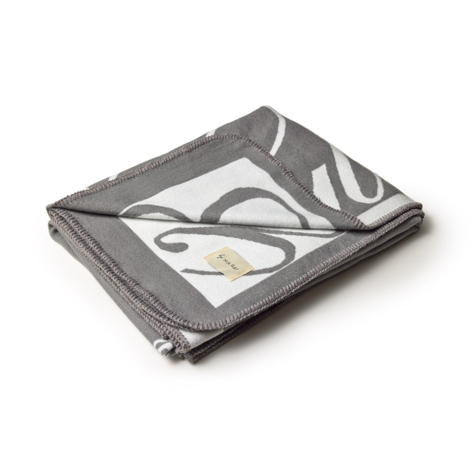 Gray luxury throw blanket with a signature logo design, folded with visible stitching and a small fabric tag.