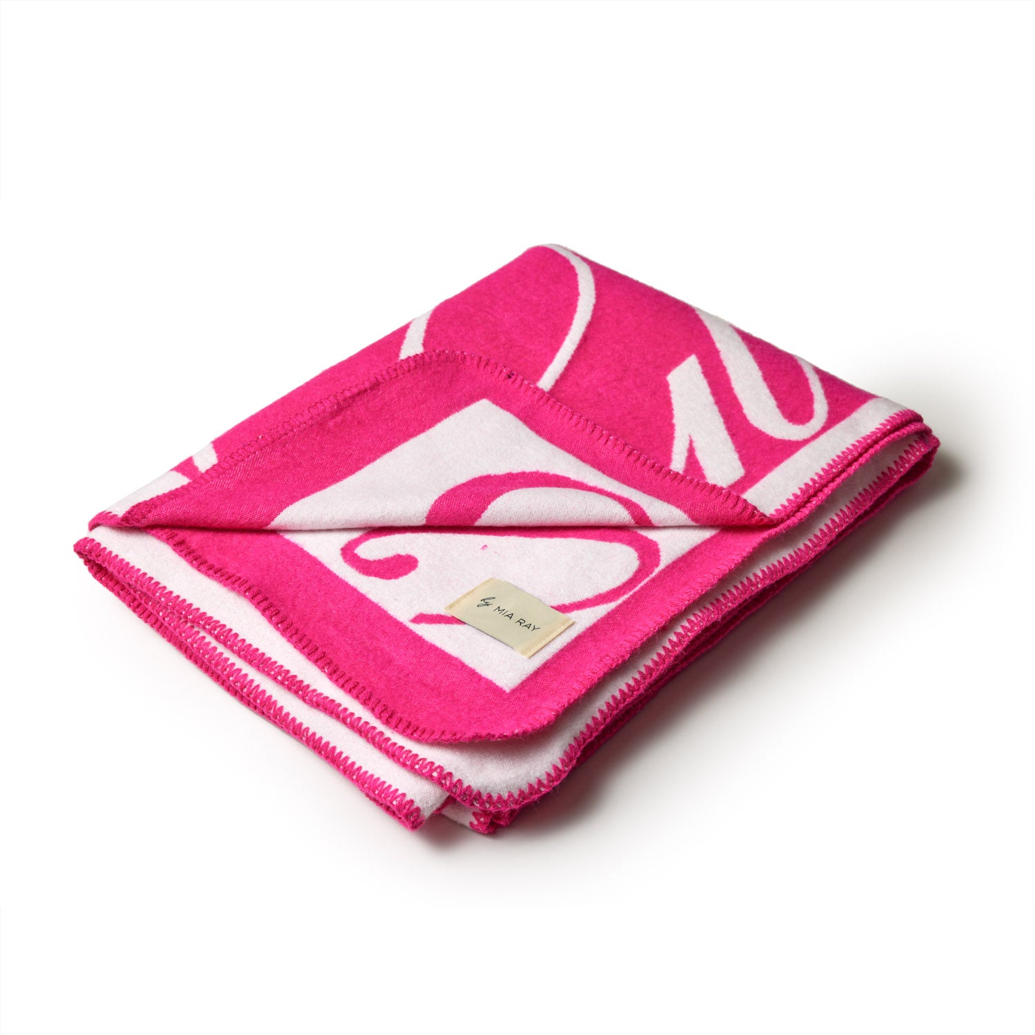 Hot pink luxury throw blanket with a signature logo design, folded to showcase vibrant color and stitched edges.