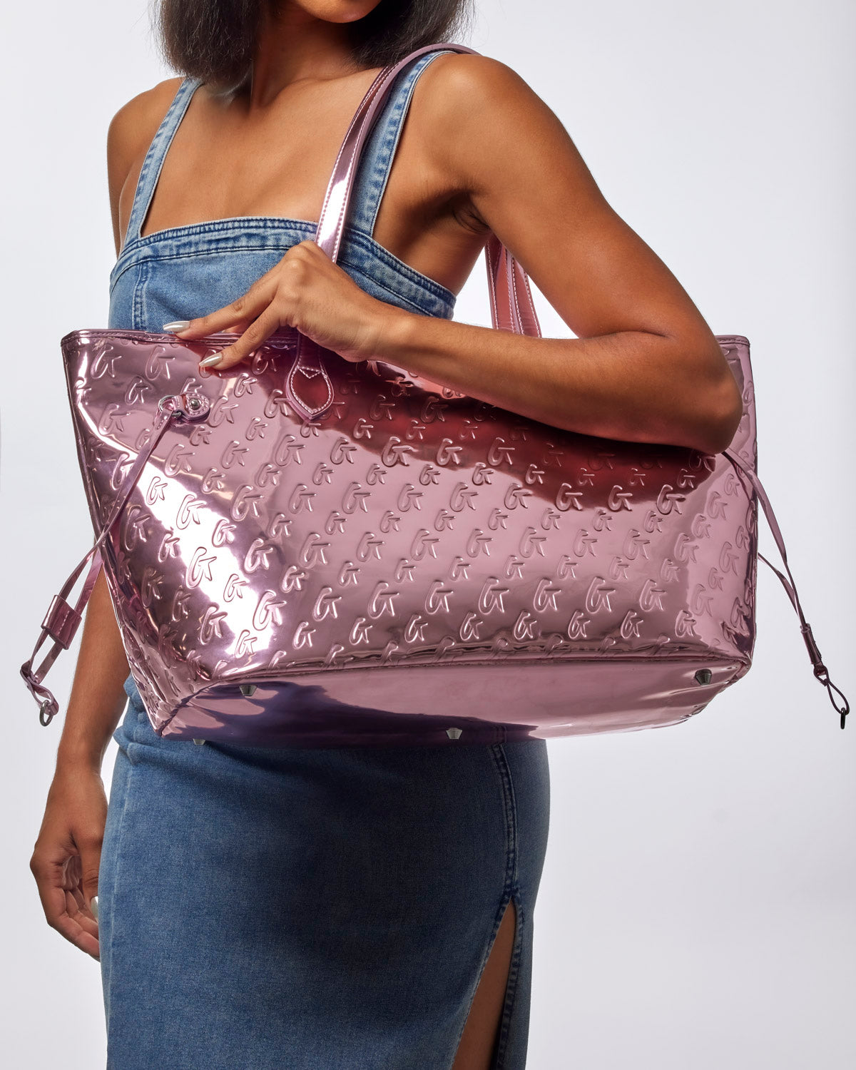 Metallic pink monogram glam tote with wristlet, featuring a stylish design and spacious interior for everyday use.