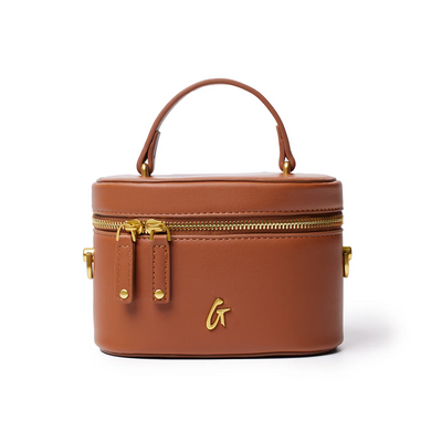 Mini smooth gold vanity bag in brown with a top handle and gold zipper accents, perfect for stylish organization.