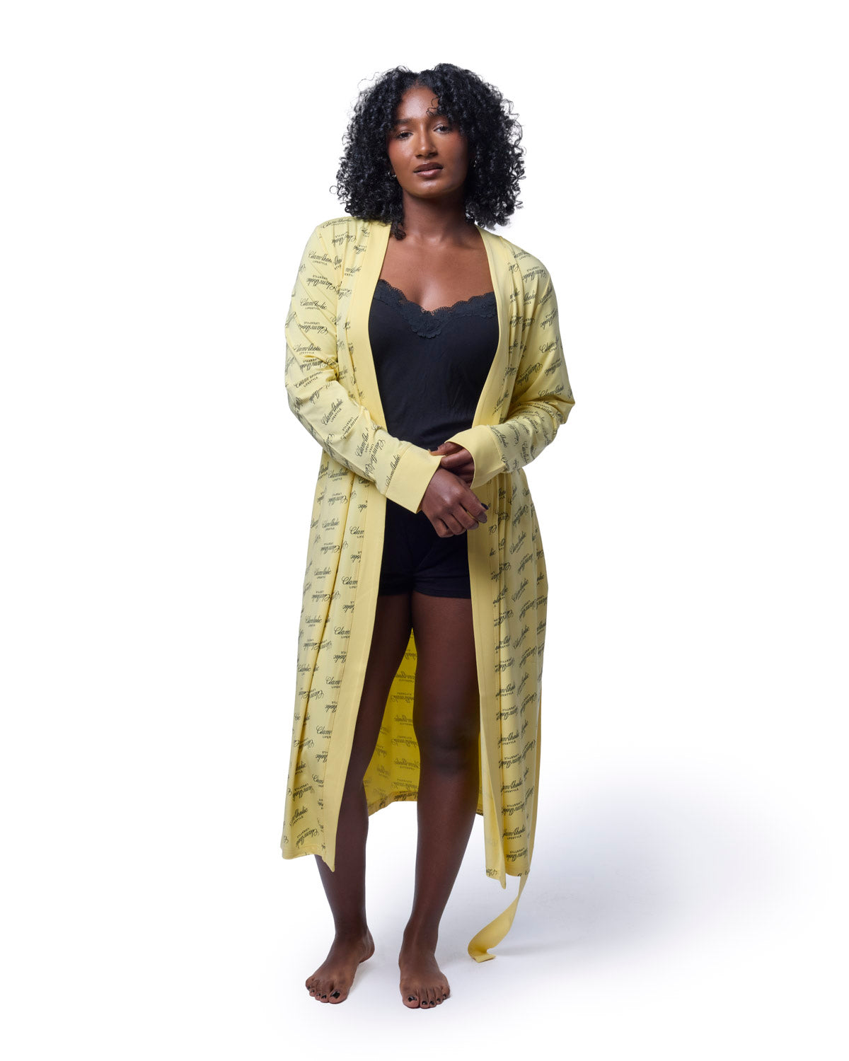 Model wearing a yellow signature luxe robe over a black camisole and shorts, showcasing a stylish and comfortable design.