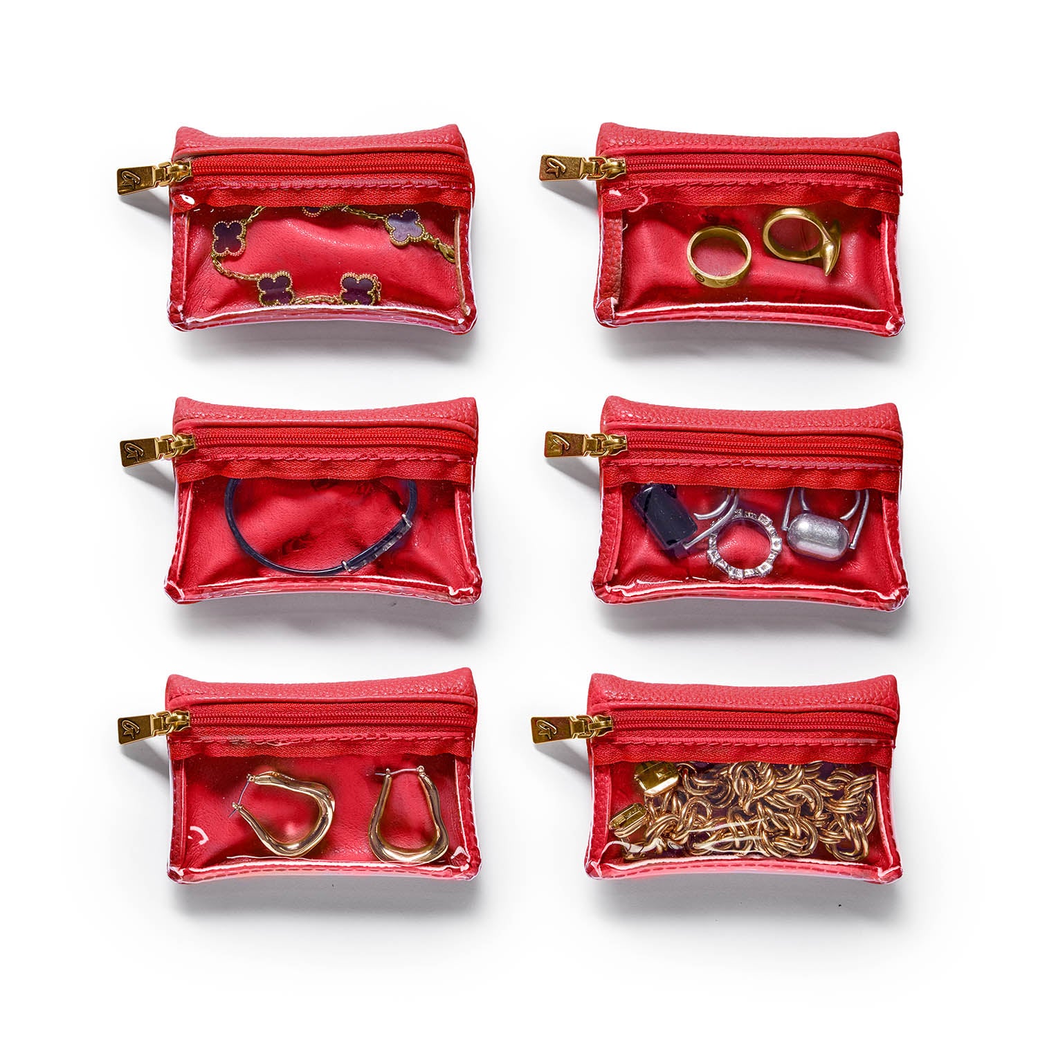 Red pebble jewelry case with transparent compartments, holding rings, earrings, bracelets, and necklaces.