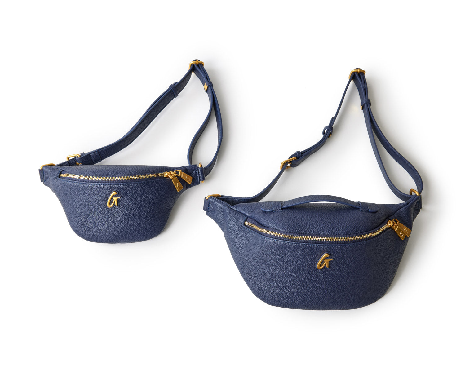 Two navy Pebble Fanny Packs with gold zippers and logo, adjustable straps, displayed on a white background.