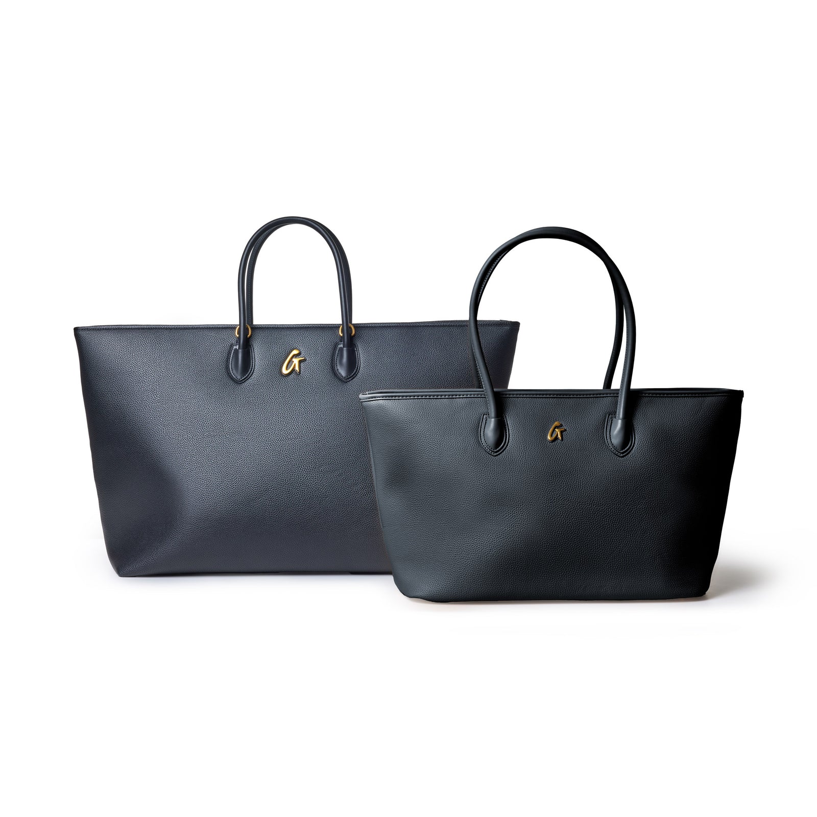 Two black leather tote bags with gold logo accents, featuring textured pebble grain and sturdy handles, on a white background.