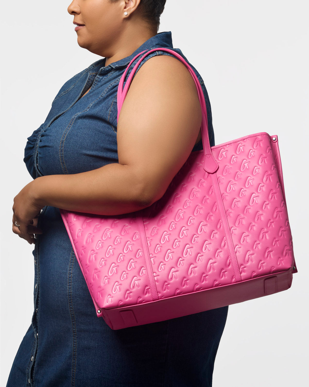 Hot pink XL monogram sleek tote bag held by a woman, showcasing its stylish design and spacious interior.