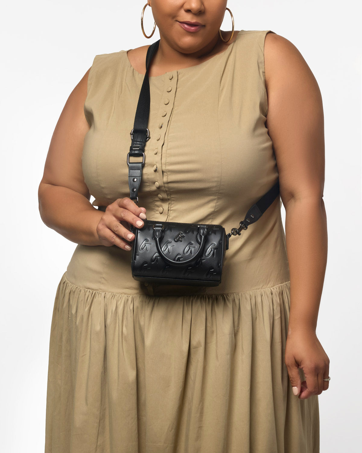 Black Nano Monogram Gal Boston Bag held by a woman in a beige dress, showcasing its stylish and compact design.