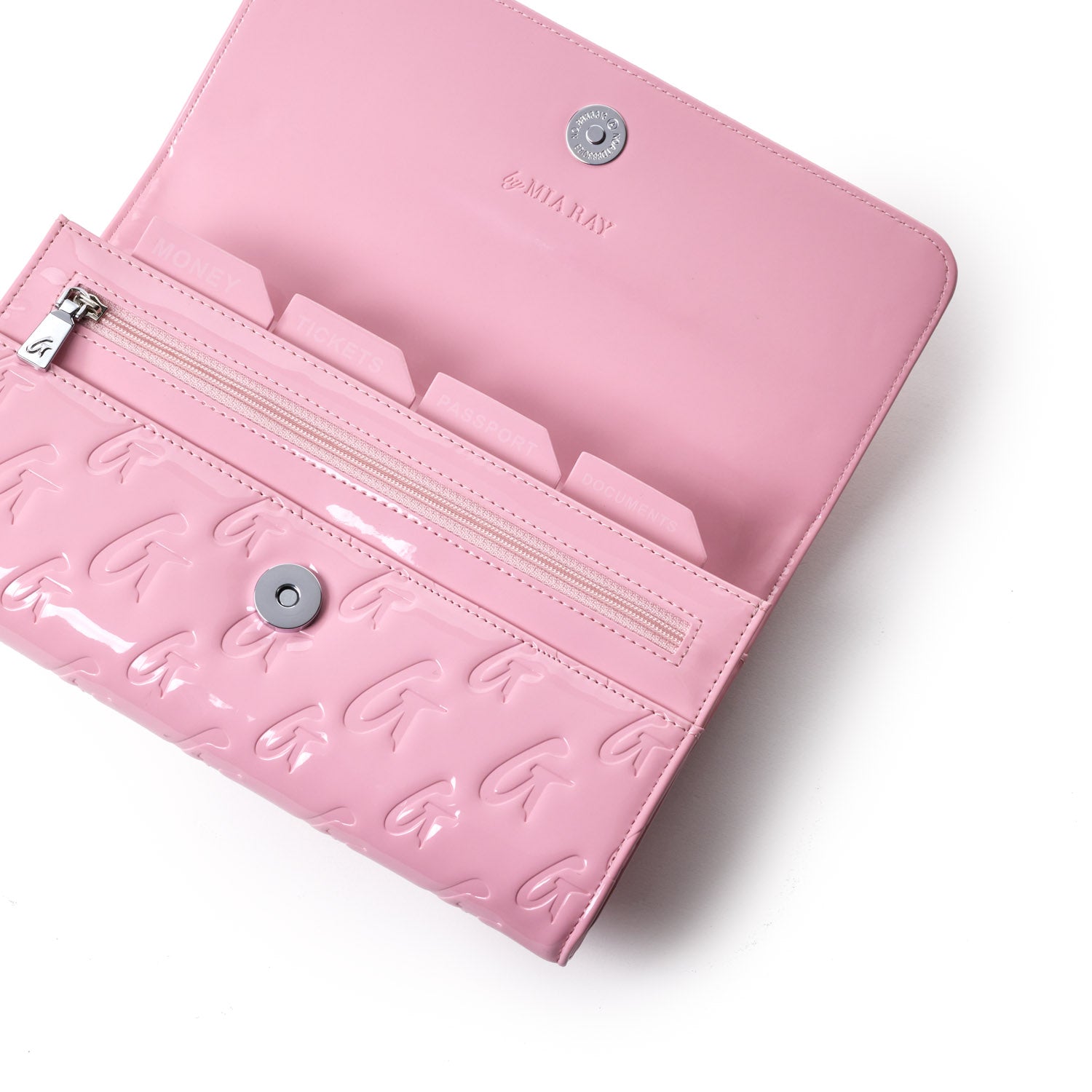 Pink travel wallet with embossed G pattern, multiple compartments, a zipper pocket, and a snap closure, designed for organization.
