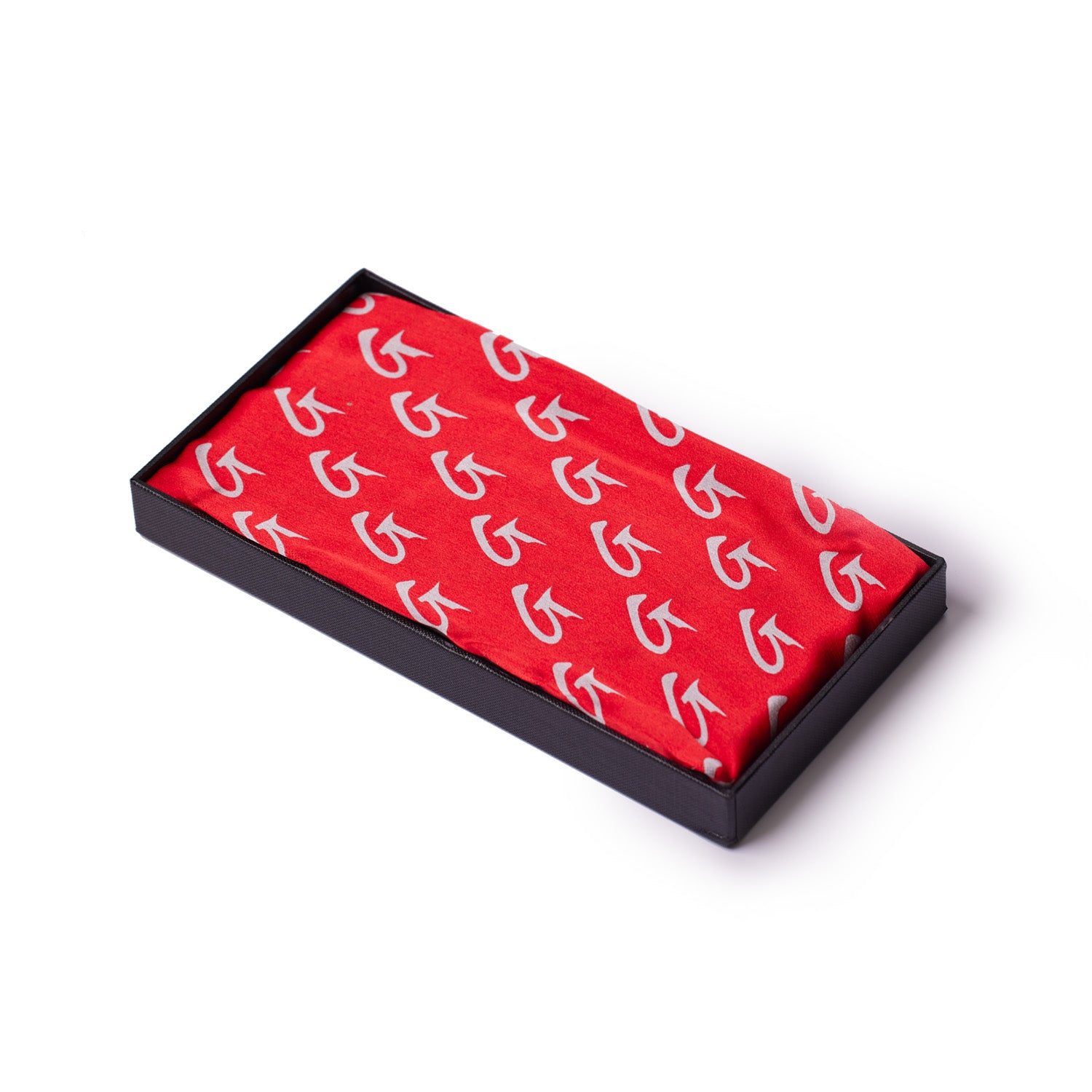 Large red silk scarf with white monogram pattern, neatly folded in a black presentation box.
