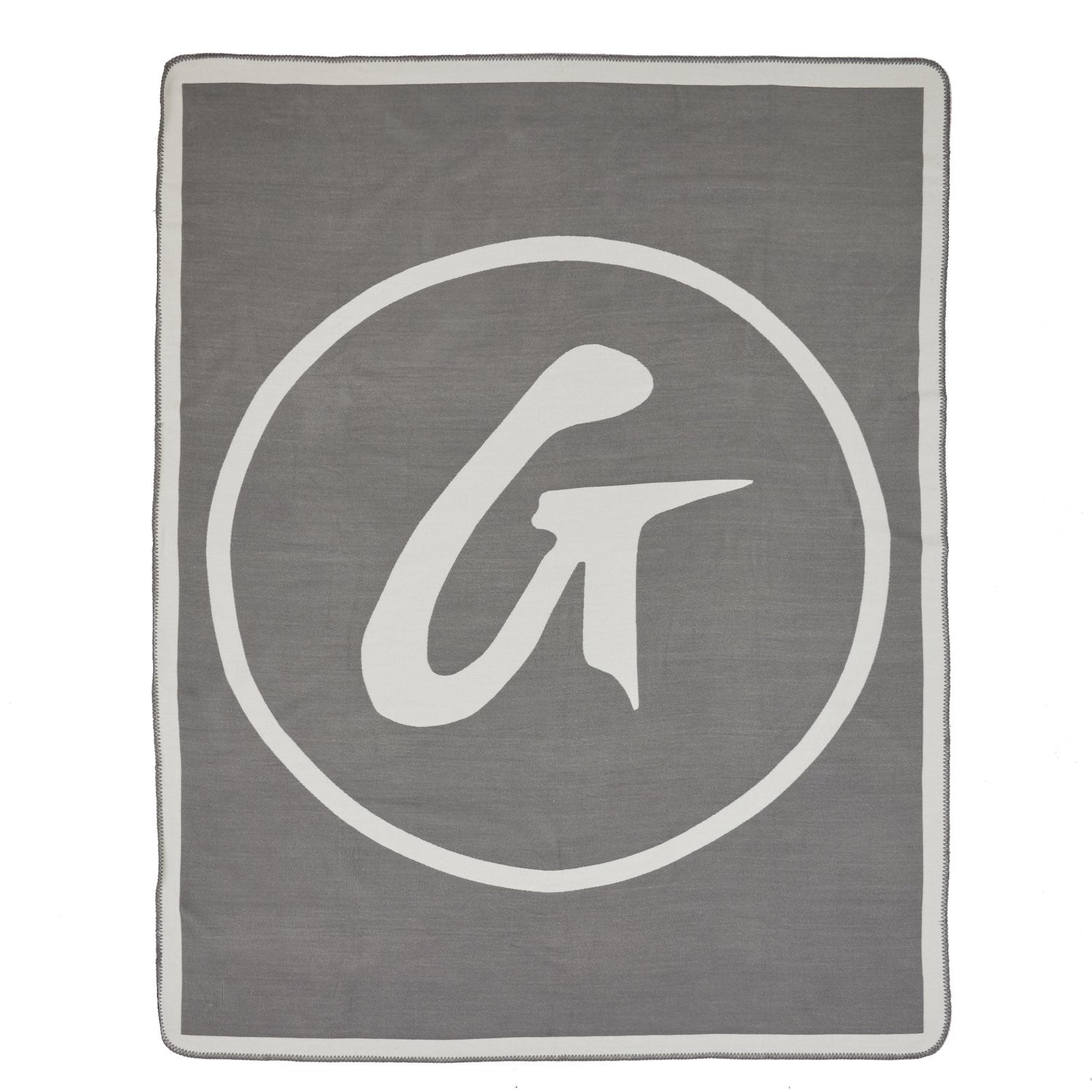 Gray throw blanket with a large white circular logo featuring a stylized "G" inside.