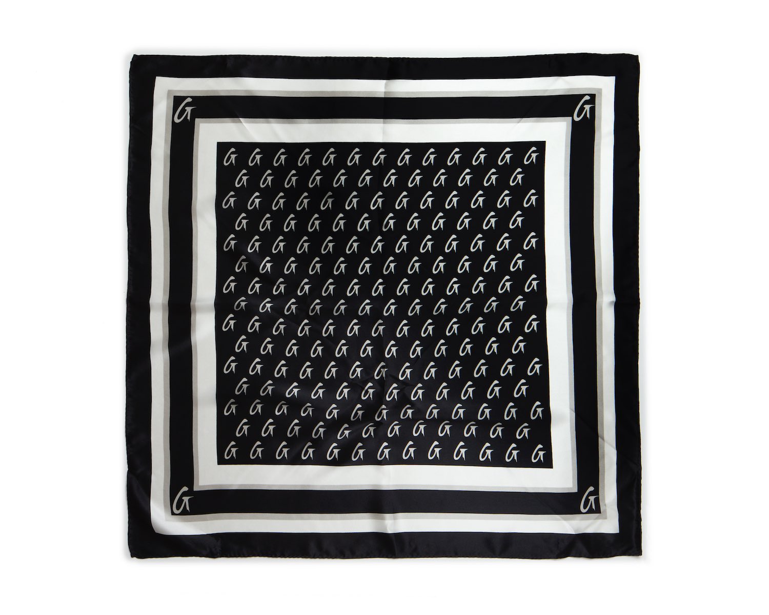 Black silk scarf with a monogram pattern, featuring white "G" initials and a border design.