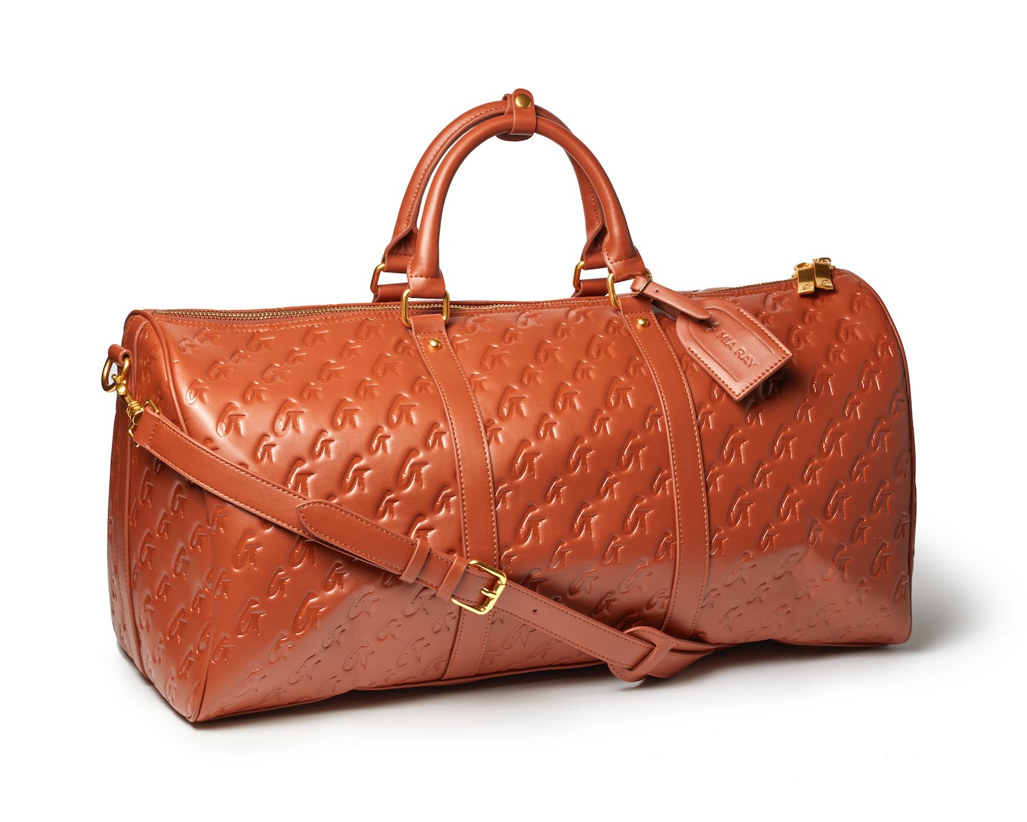 Brown unisex duffle bag with embossed monogram pattern, gold hardware, top handles, and adjustable shoulder strap.